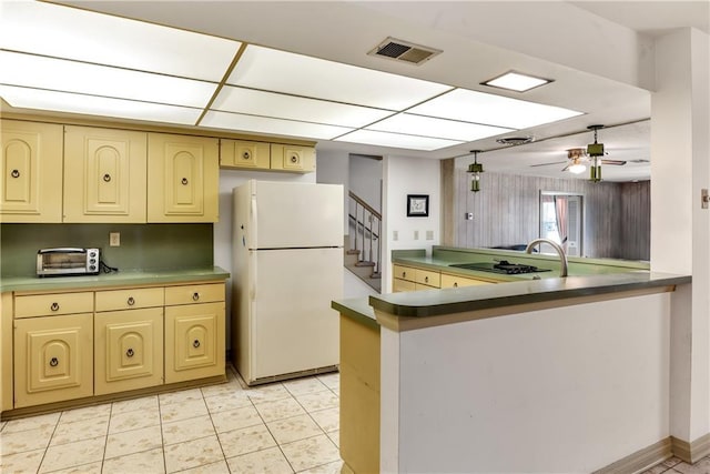 kitchen featuring visible vents, a toaster, freestanding refrigerator, ceiling fan, and cream cabinets