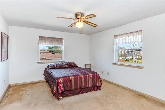 bedroom with baseboards, multiple windows, a ceiling fan, and carpet flooring