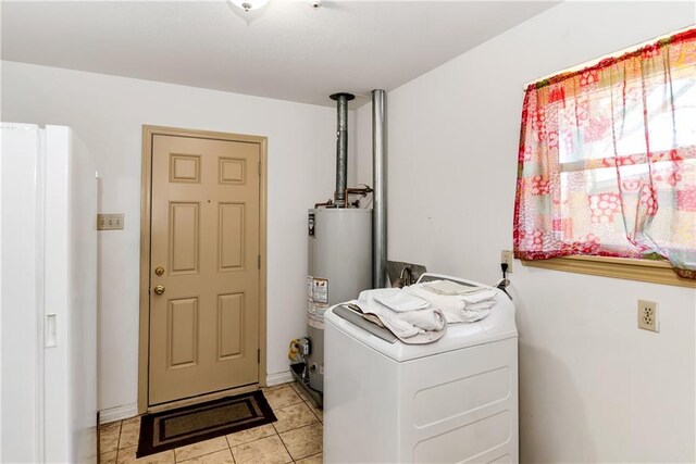 washroom featuring water heater, laundry area, washer / dryer, and light tile patterned floors