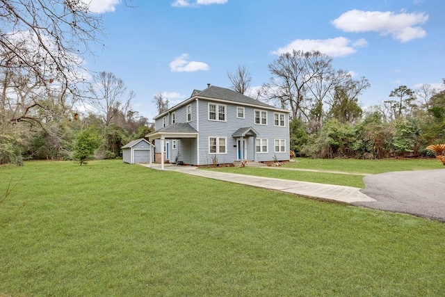 colonial home featuring a garage, driveway, an outdoor structure, and a front yard