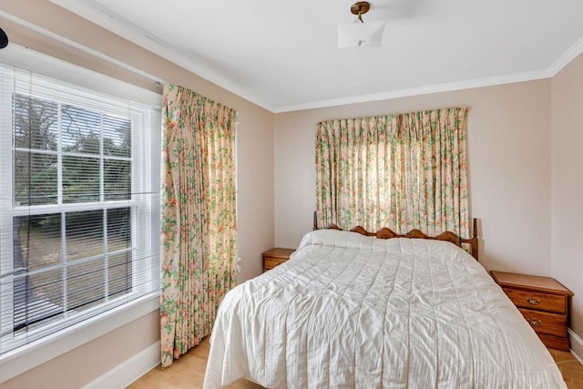 bedroom with wood finished floors, baseboards, and ornamental molding