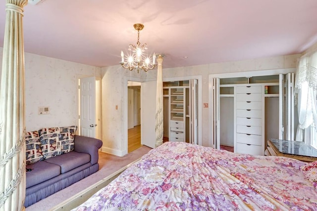 bedroom featuring an inviting chandelier, wallpapered walls, carpet, and multiple closets
