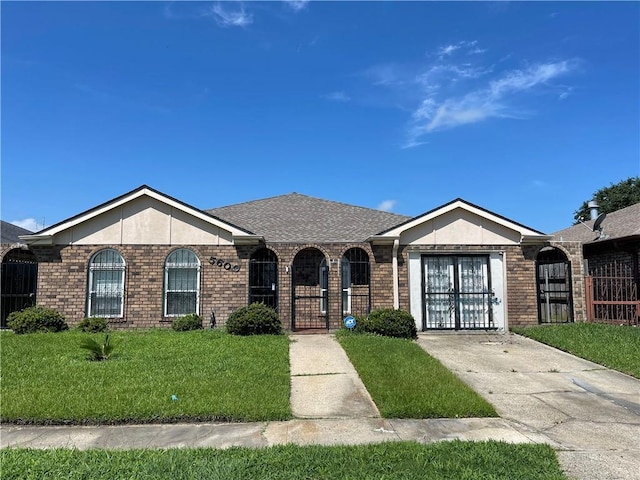 ranch-style house with a gate, fence, an attached garage, a front yard, and brick siding