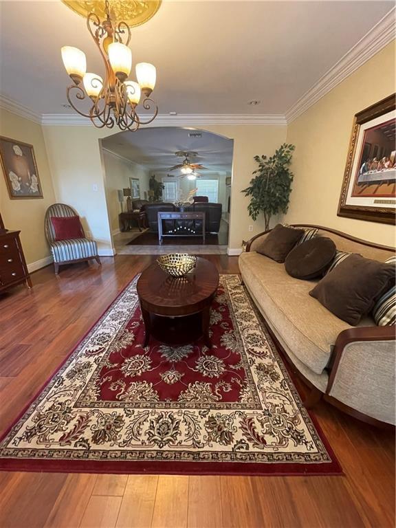 living room with ornamental molding, baseboards, and wood finished floors