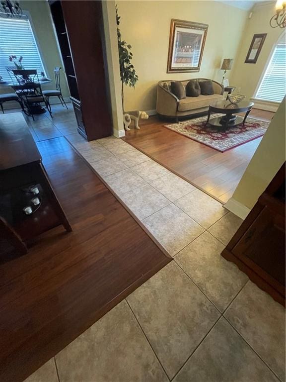 living room with baseboards, a chandelier, and tile patterned flooring