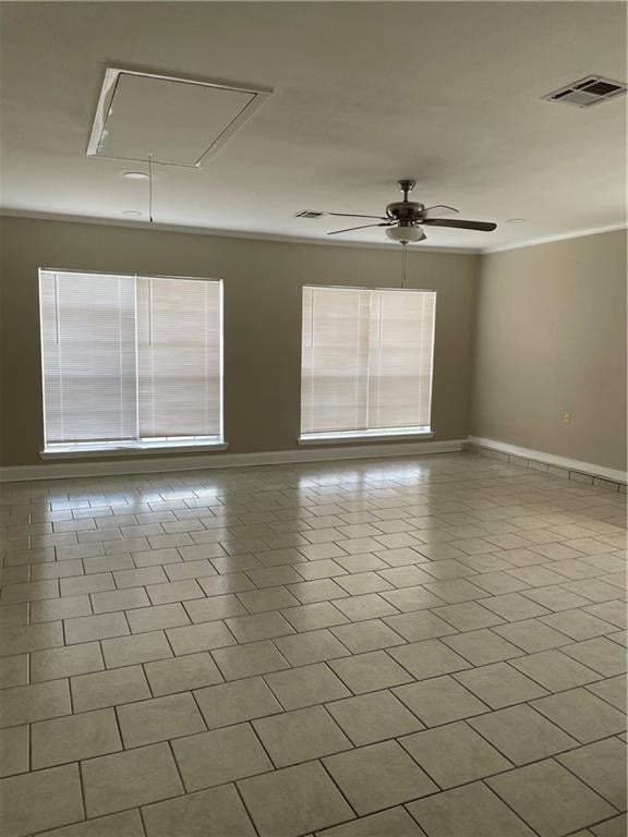 tiled spare room featuring visible vents, a healthy amount of sunlight, attic access, and baseboards