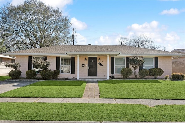 ranch-style house with a front yard, brick siding, and roof with shingles