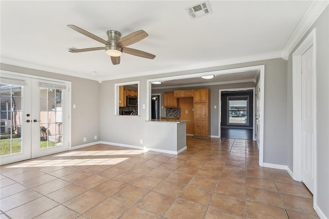 spare room with french doors, plenty of natural light, visible vents, and ornamental molding