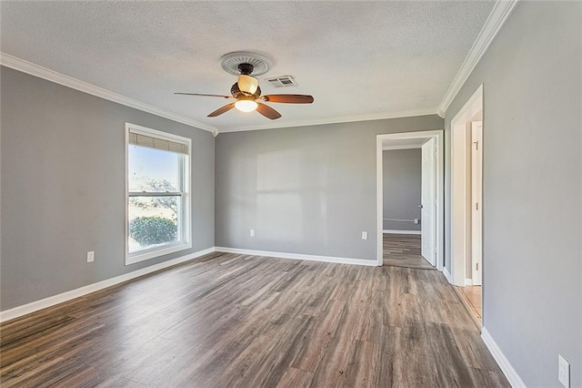 empty room with a textured ceiling, crown molding, baseboards, and wood finished floors