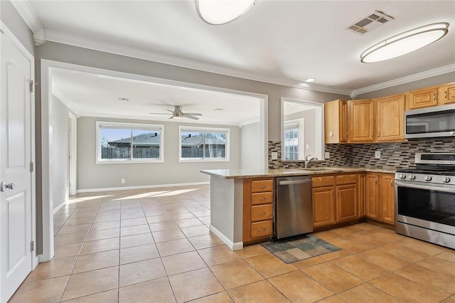 kitchen with visible vents, a sink, decorative backsplash, stainless steel appliances, and crown molding