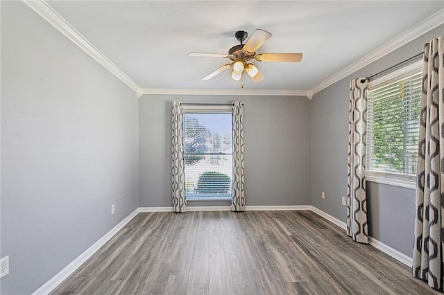 empty room with crown molding, plenty of natural light, wood finished floors, and baseboards