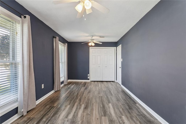 interior space with visible vents, wood finished floors, baseboards, and ceiling fan