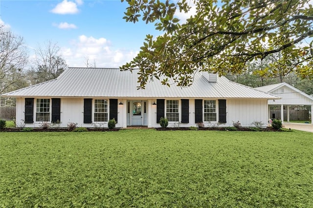 ranch-style home with metal roof, a carport, and a front lawn