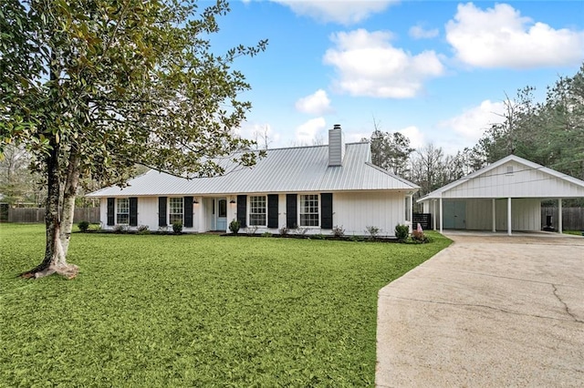 ranch-style home with fence, concrete driveway, a front yard, a carport, and a chimney