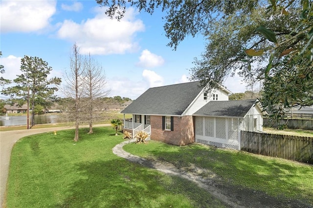 view of front of house featuring a front yard, fence, and brick siding