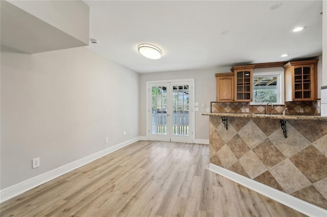 unfurnished living room with recessed lighting, baseboards, and light wood-type flooring