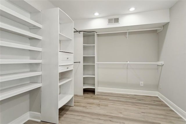 spacious closet featuring visible vents and wood finished floors