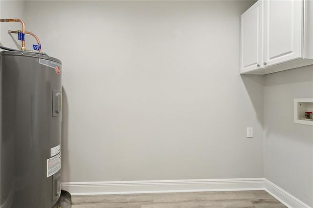 laundry area with electric water heater, baseboards, washer hookup, wood finished floors, and cabinet space