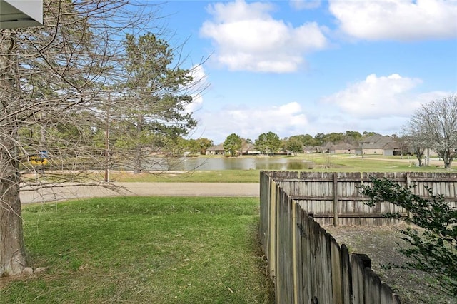 view of yard with a water view and fence