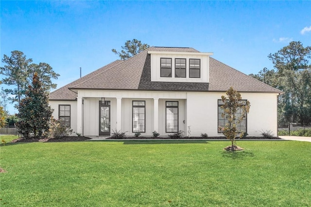 view of front of property featuring a front yard and roof with shingles