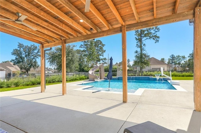 view of pool featuring a patio, fence, a fenced in pool, and a water slide