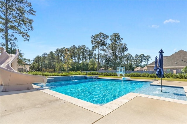 outdoor pool with a patio and a water slide