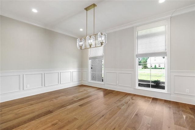 unfurnished dining area featuring a decorative wall, recessed lighting, light wood finished floors, and ornamental molding