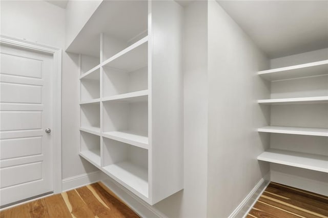 walk in closet with wood finished floors