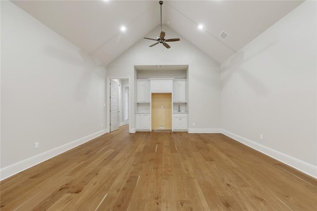 interior space featuring visible vents, high vaulted ceiling, light wood-type flooring, and baseboards