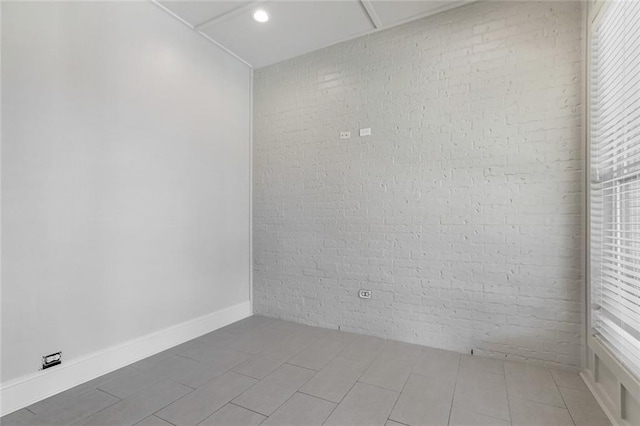 unfurnished room with recessed lighting and brick wall