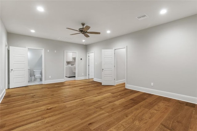 unfurnished bedroom featuring washer / dryer, light wood-style floors, visible vents, and connected bathroom