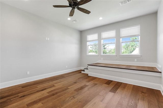 unfurnished room with wood finished floors, visible vents, and baseboards