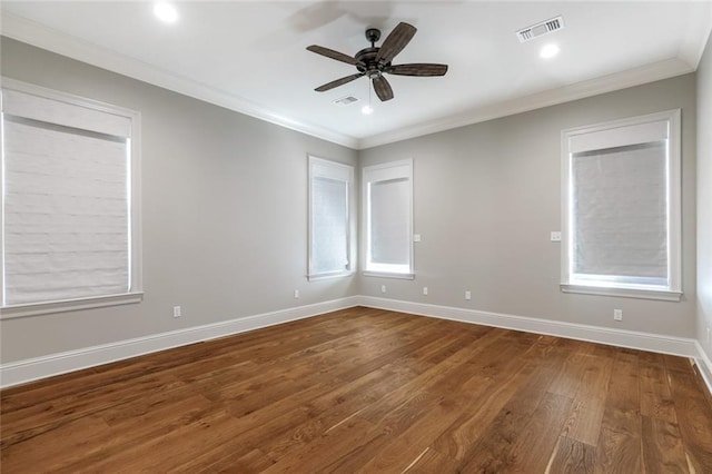 empty room with visible vents, dark wood-type flooring, baseboards, and ornamental molding