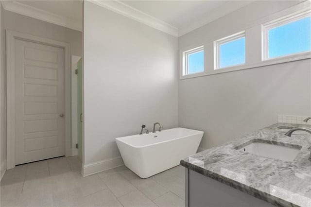 full bathroom with tile patterned floors, a freestanding tub, a sink, crown molding, and double vanity