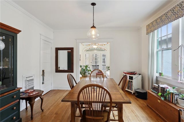 dining space featuring heating unit, hardwood / wood-style floors, and crown molding