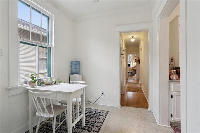 dining room featuring baseboards, a wealth of natural light, and ornamental molding