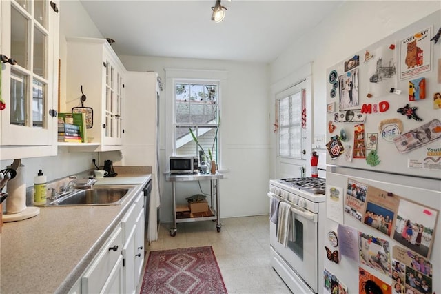 kitchen featuring a sink, white appliances, white cabinets, and light countertops