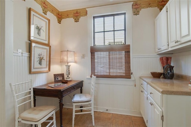 interior space with light tile patterned floors and wainscoting