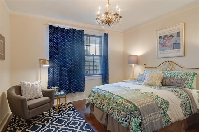 bedroom with baseboards, an inviting chandelier, wood finished floors, and crown molding