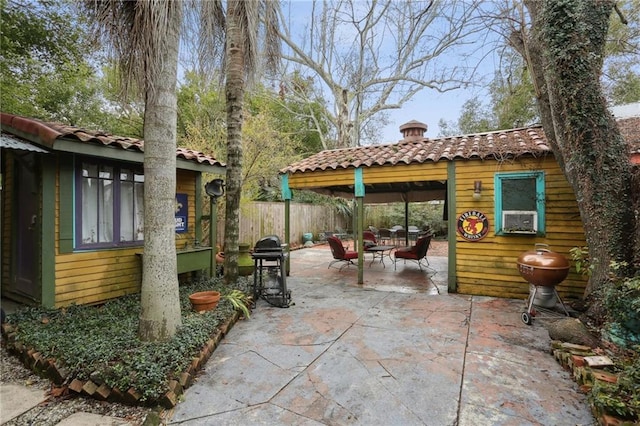 view of patio featuring cooling unit, an outbuilding, and fence