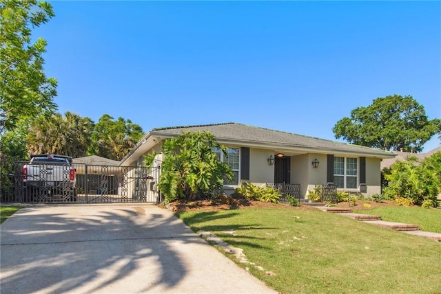 view of front facade with stucco siding, a gate, fence, concrete driveway, and a front yard