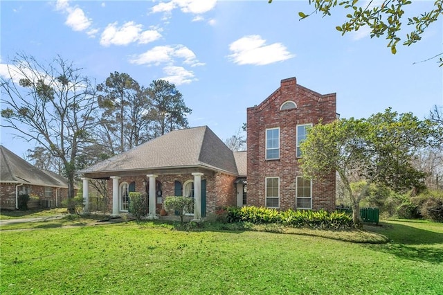 view of front facade featuring a front yard, brick siding, and a shingled roof