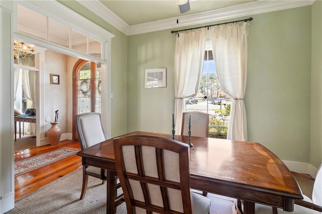 dining area featuring a healthy amount of sunlight, crown molding, baseboards, and wood finished floors