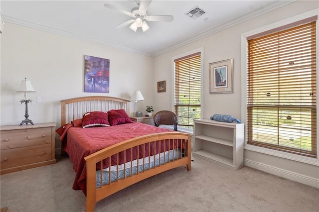 carpeted bedroom featuring visible vents, ceiling fan, baseboards, and ornamental molding