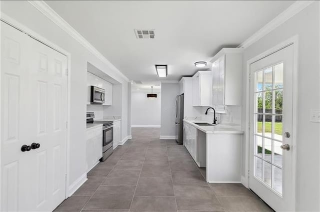 kitchen featuring visible vents, ornamental molding, a sink, light countertops, and appliances with stainless steel finishes