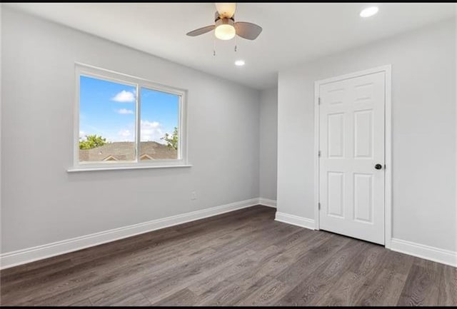 empty room featuring dark wood finished floors, recessed lighting, and baseboards