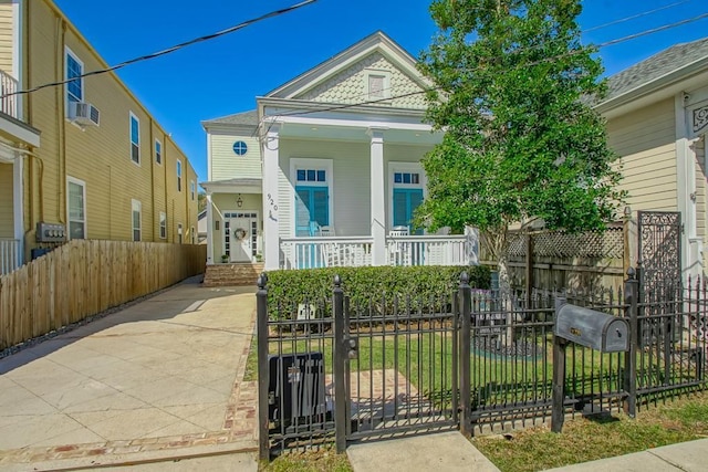 view of front of home featuring a fenced front yard, covered porch, and a gate