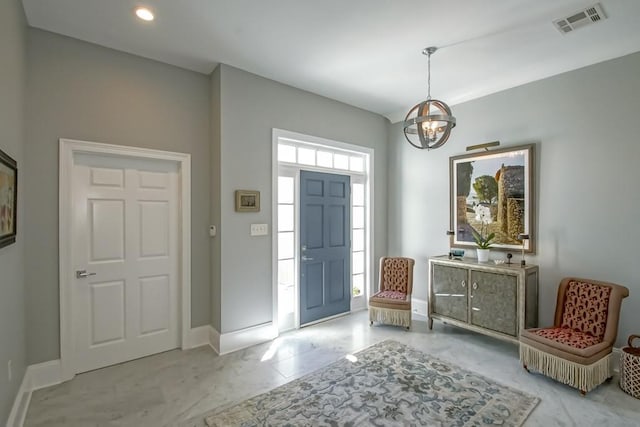 foyer with a notable chandelier, visible vents, marble finish floor, and baseboards