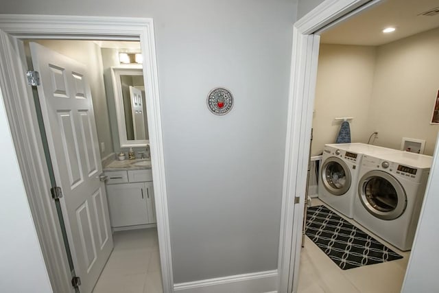 washroom with light tile patterned floors, visible vents, laundry area, a sink, and independent washer and dryer