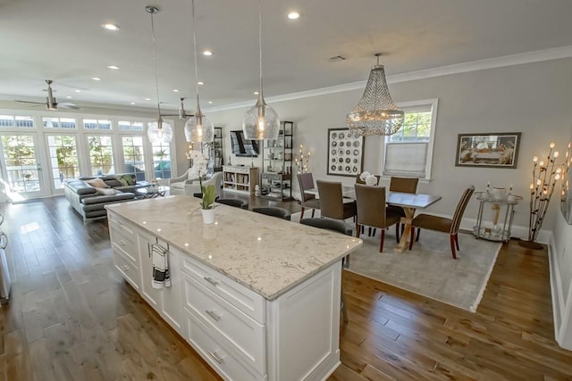 kitchen with a center island, crown molding, open floor plan, white cabinets, and dark wood-style flooring